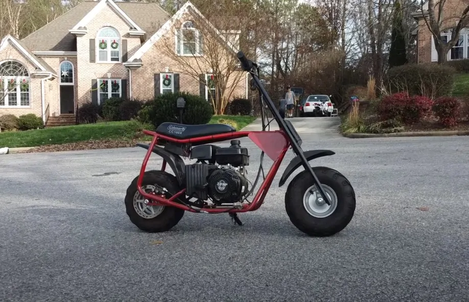 Red Coleman mini bike parked on the street