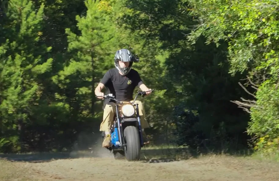 Guy driving Mega Moto Mini Bike in nature