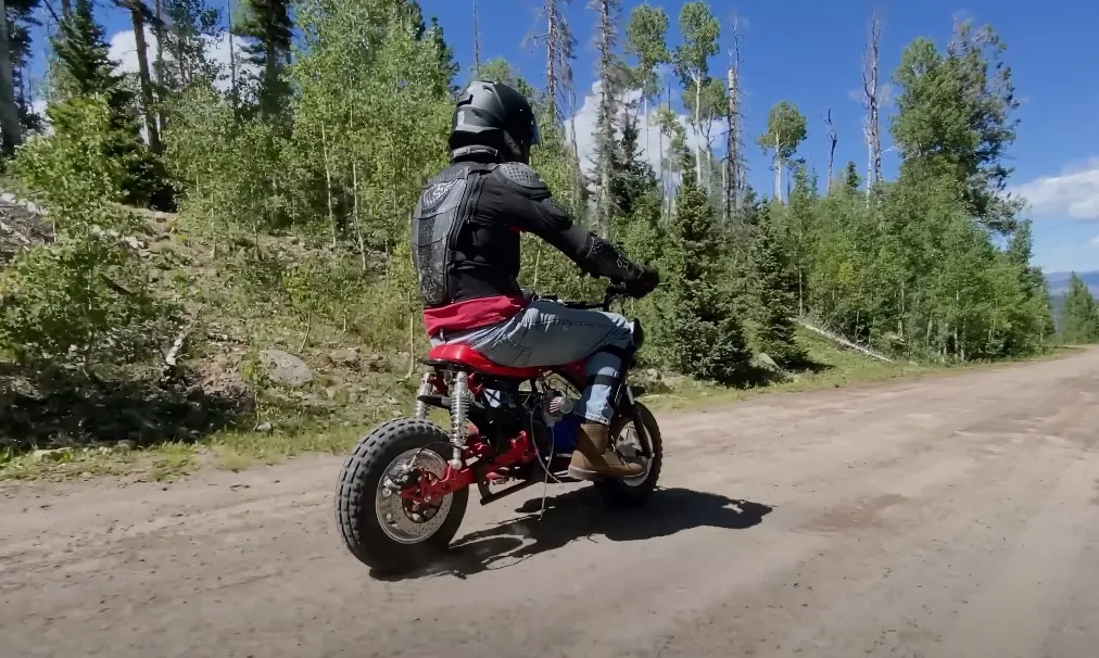 Guy with a helmet rides mini bike on a dirt terrain