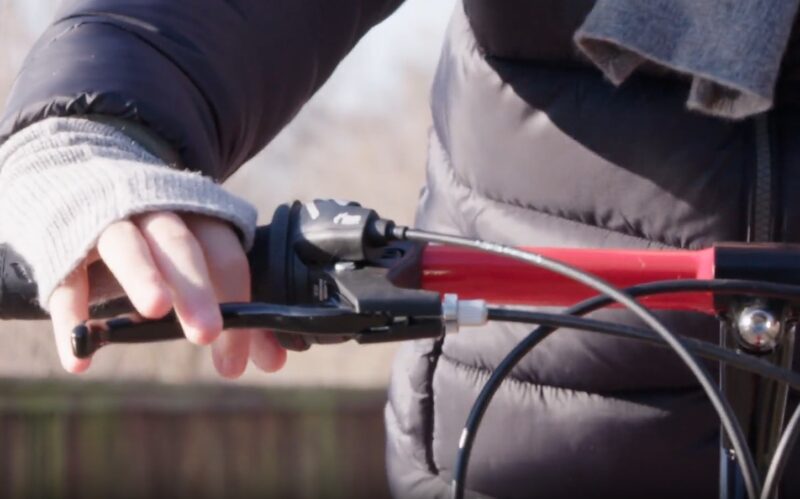 A kid is pressing brake levers with his hands