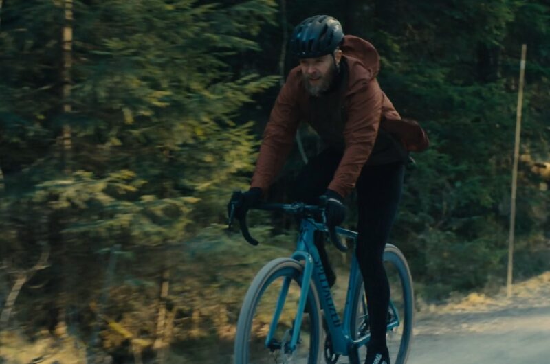 A guy rides a bike on a cold day