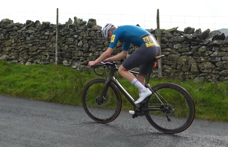 Cyclist in a blue shirt rides a bike uphill