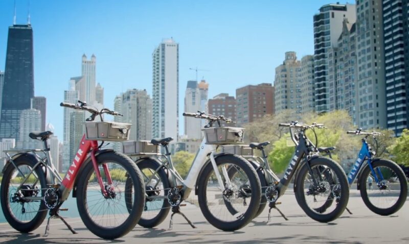 Different types of e-bikes in front of big buildings