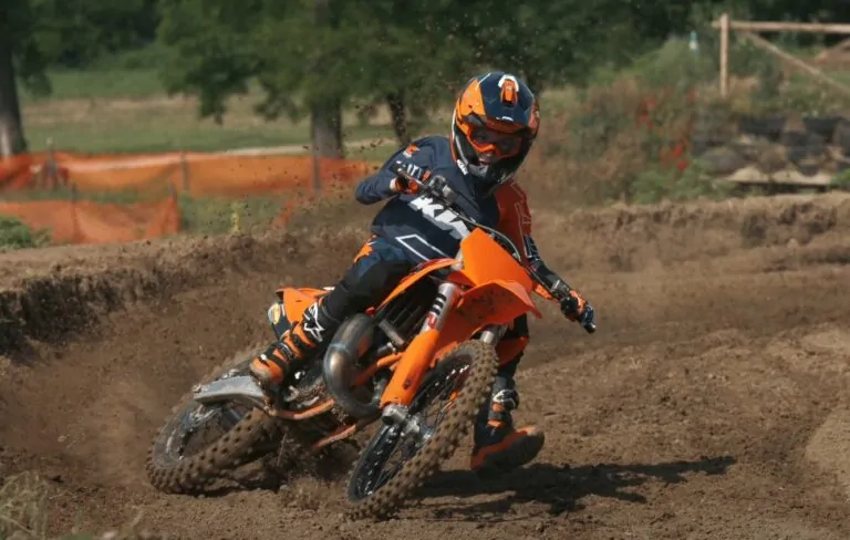 Guy rides KTM dirt bike on a dirt track