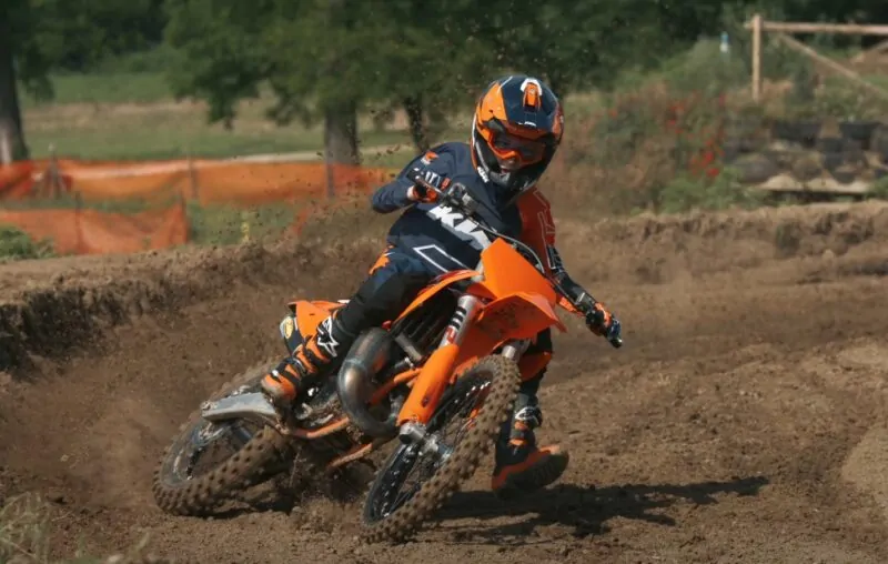 Guy rides KTM dirt bike on a dirt track