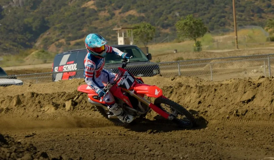 Guy rides Honda dirt bike during a race