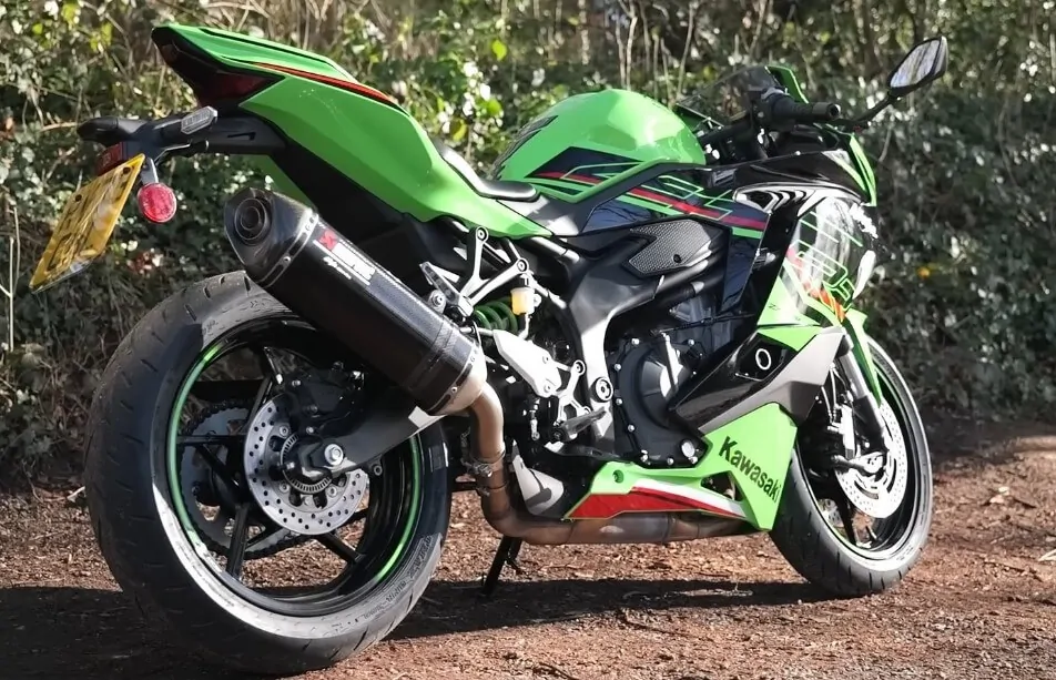 Green motorcycle parked on the dirt