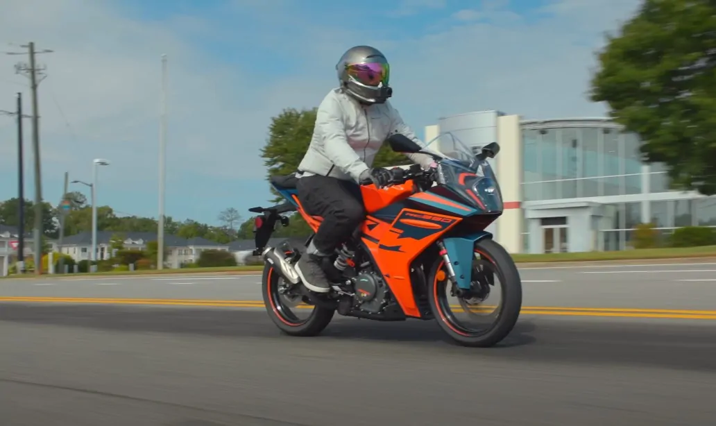 Biker with helmet rides orange motorcycle