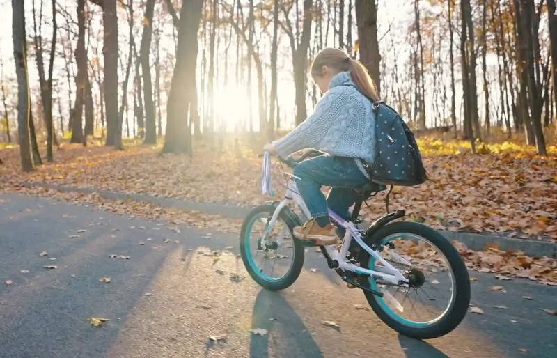 Girl rides a bike in autumn