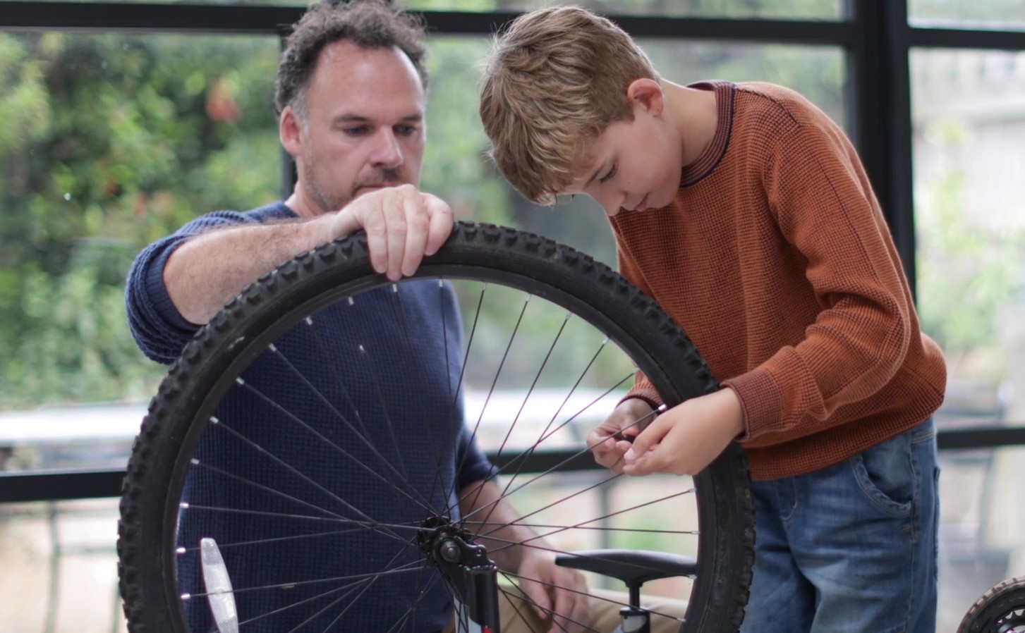 Father and son measuring bike wheel