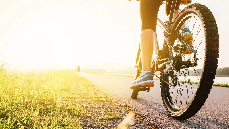 A Cyclist Riding on A Scenic Path During Sunset, Focusing on Avoiding Cycling Injuries for A Pain-Free Ride