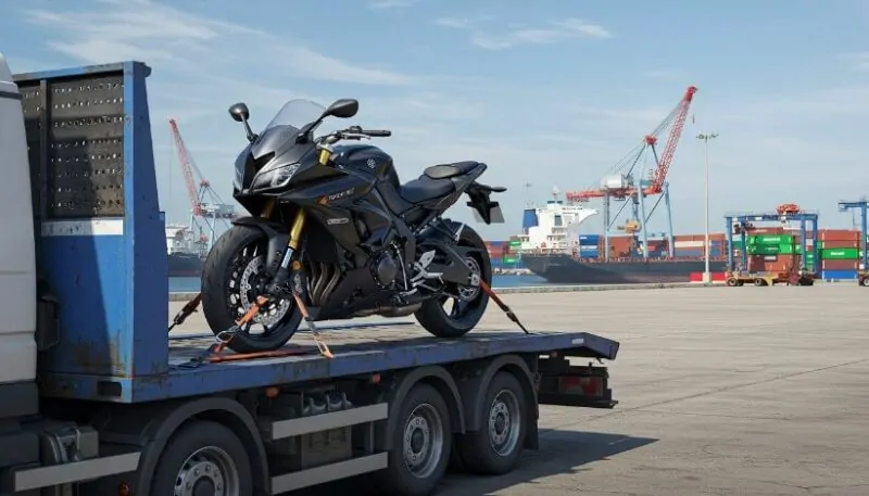 A sleek motorcycle, securely strapped to a flatbed truck, ready for transport
