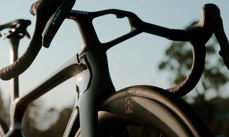 Aero-sculpted Cervélo handlebars and dark frame against a bright, hazy sky