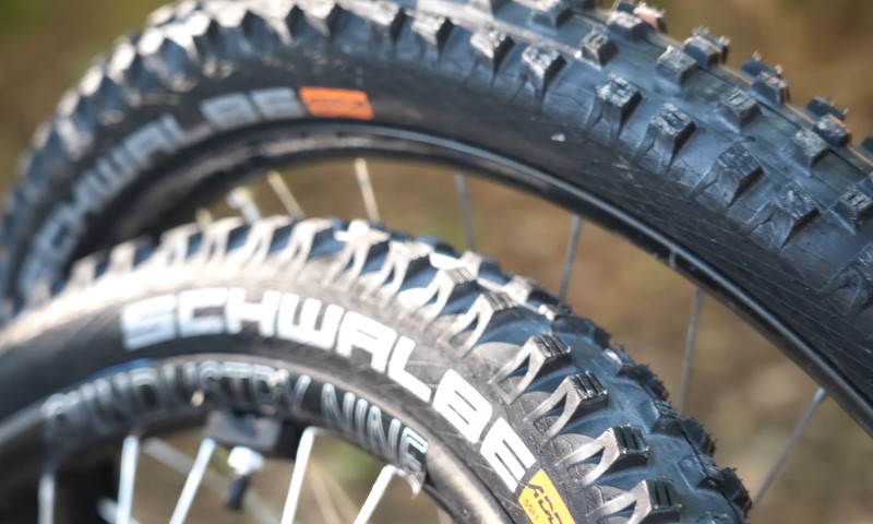 Close-up of two black Schwalbe mountain bike tires with prominent treads