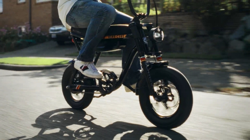 Teen riding a Schwinn Hurricane Compact electric bike on a neighborhood street