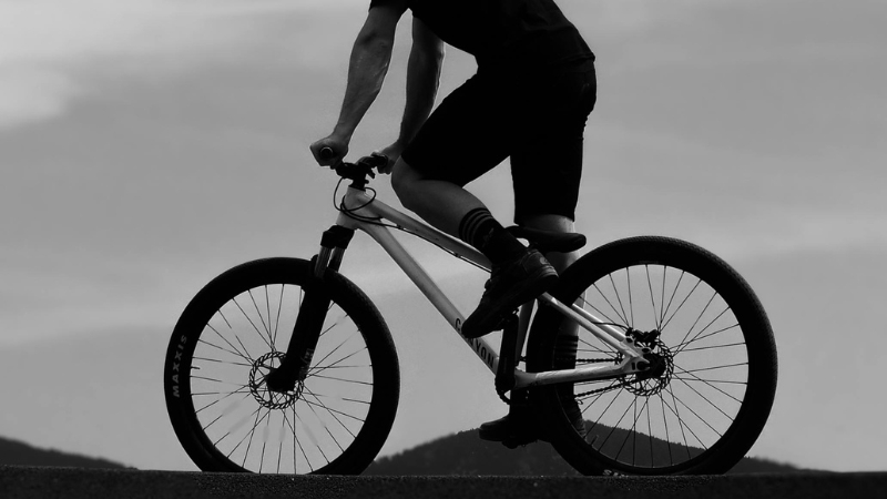 A cyclist rides an electric bicycle on a paved road